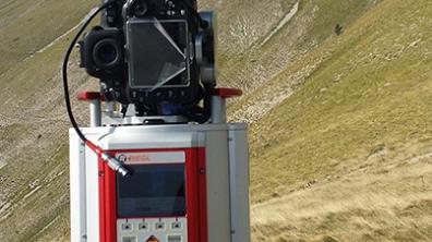 Appareil de mesure laser qui reproduit la topographie avec une grande précision. A l'arrière-plan, le flanc de la montagne avec la faille qui a bougé lors du séisme. 